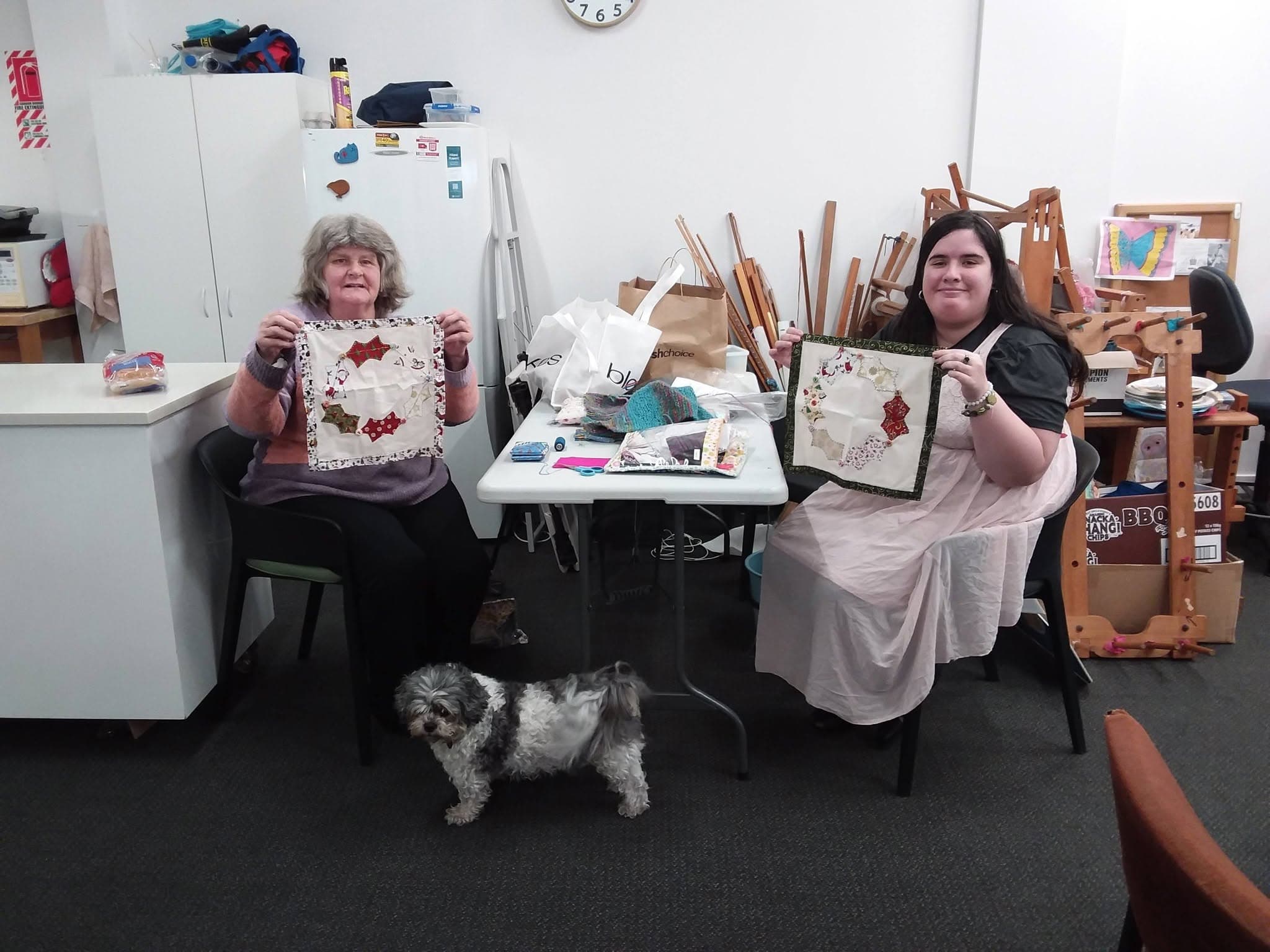 Clients showing their craft work with the studio dog